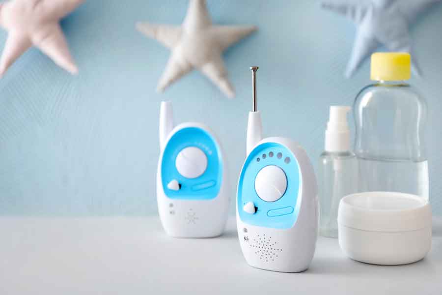 Analog Baby Monitors with a bottle of milk on a table. Star decorations on the wall in the background