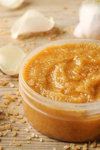 Image of Sugar Scrub on table with flower petals in the background