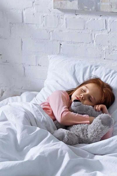 Child sleeping on white bedsheets - Kid's Organic Bedding Featured Image