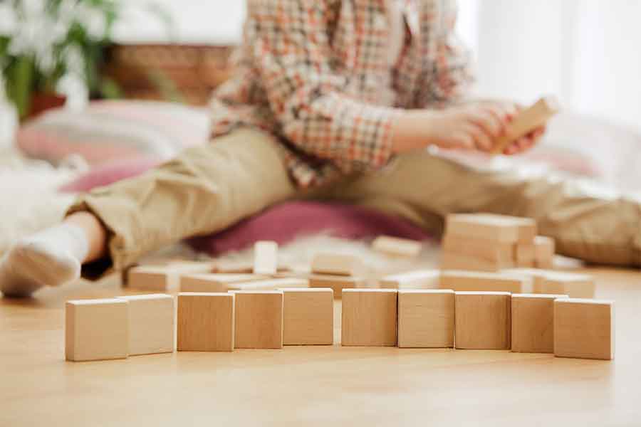 Kid in the background playing with wooden blocks