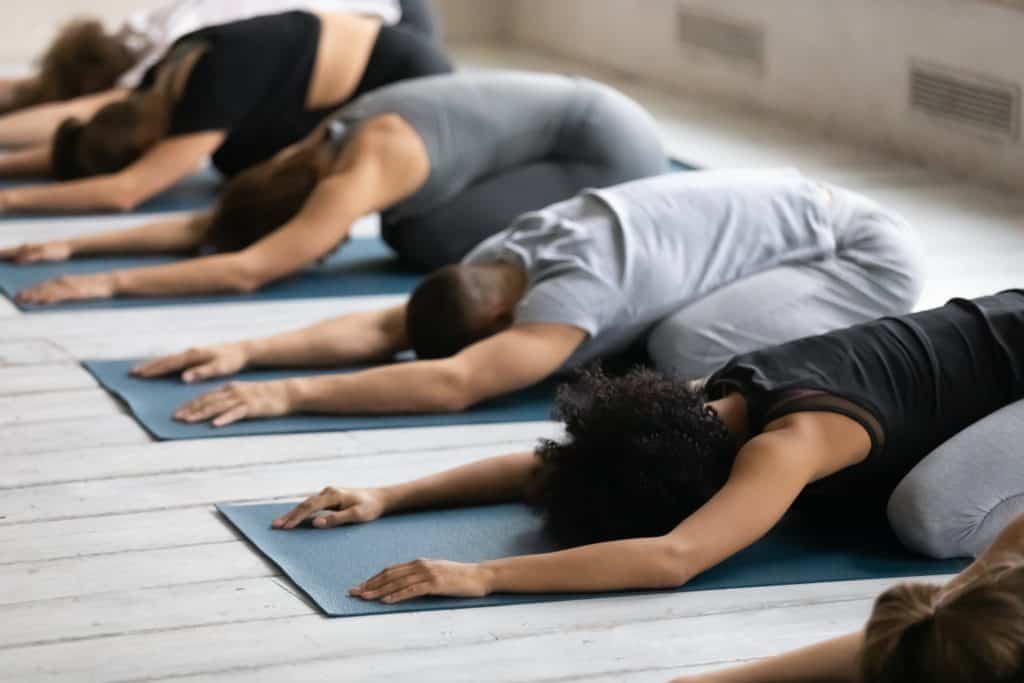 young fit group of people doing yoga on non-toxic yoga mats